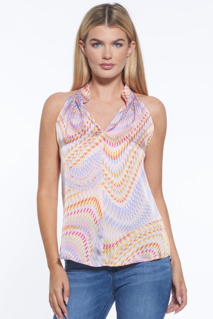 Woman wearing a patterned sleeveless top and blue jeans on a white background