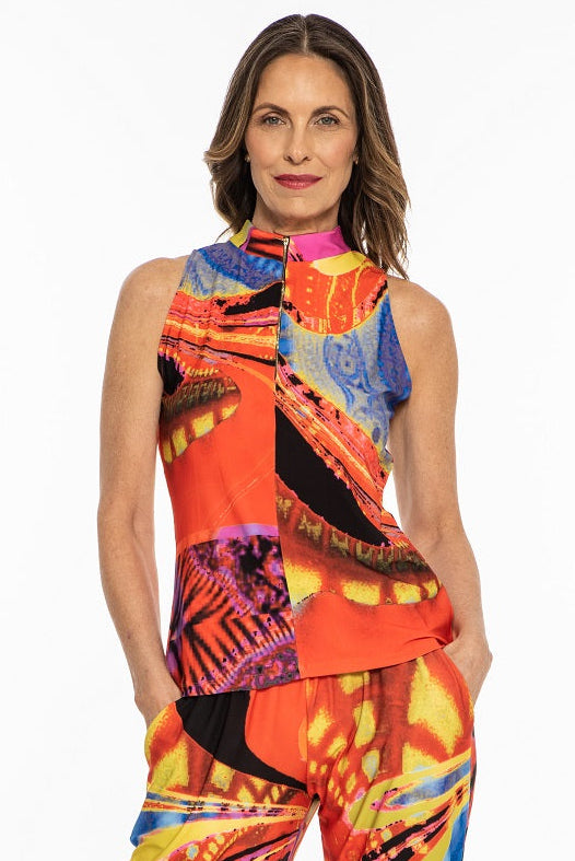 A female model wearing a sleeveless, high-necked, fitted top with a colorful, abstract print and matching pants.